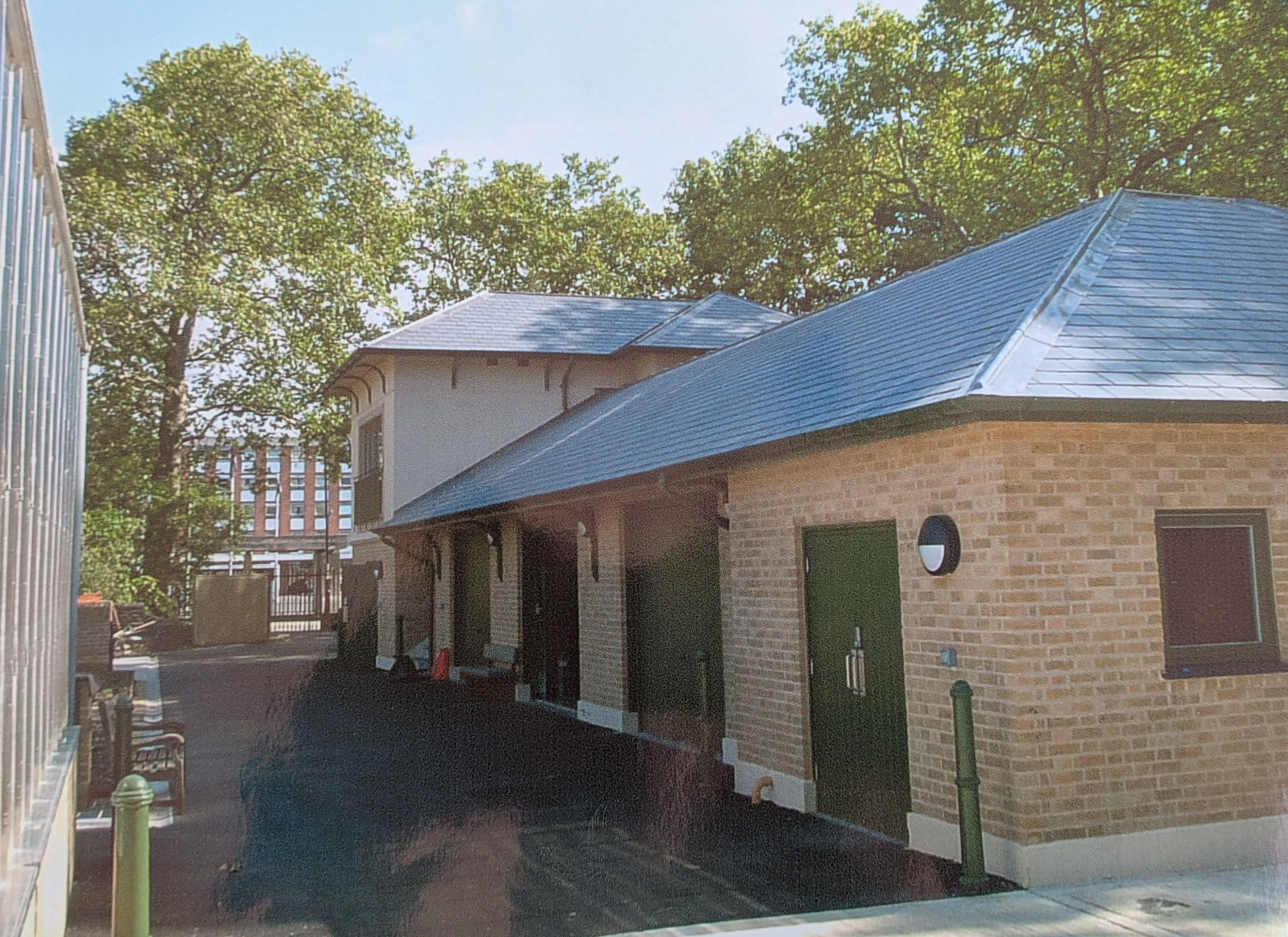 Brick outbuilding with slate roof and green doors, built by MMA Construction